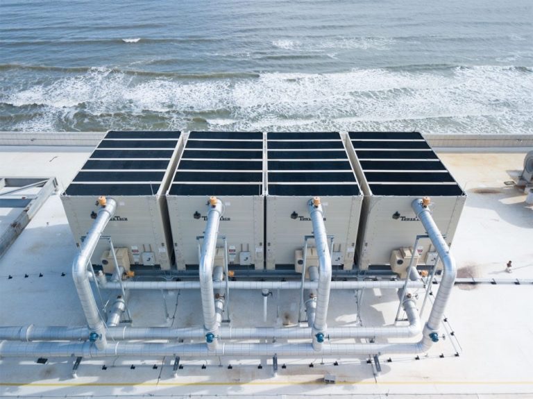 Industrial cooling units aerial view near ocean